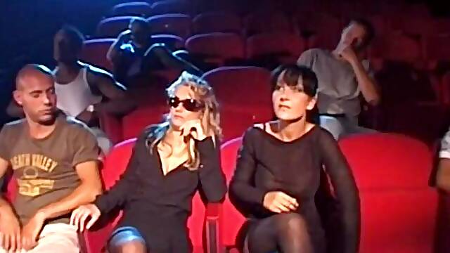 Blonde and brunette gang fucked in a porn theater