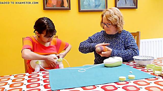 Old woman teaching youthful woman to pump breast milk